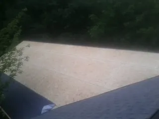 New OSB roof sheathing installed beside an existing shingle roof in Denver