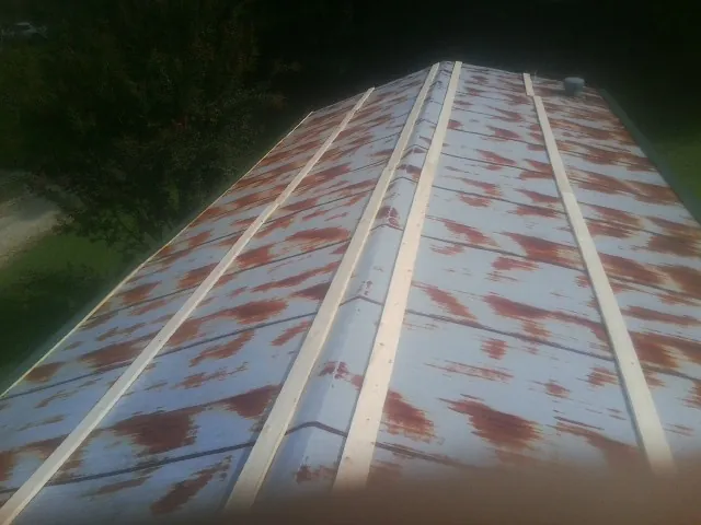 Rusted metal roof panels with new wood purlins before replacement — Storm Damage Roof Repair in Denver by Roofing Brothers